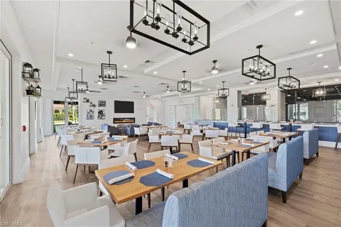 a very nice looking open dining room with kitchen island stainless steel appliances a fireplace a flat screen tv and a view of living room