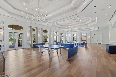 a view of a dining room with furniture a chandelier and wooden floor