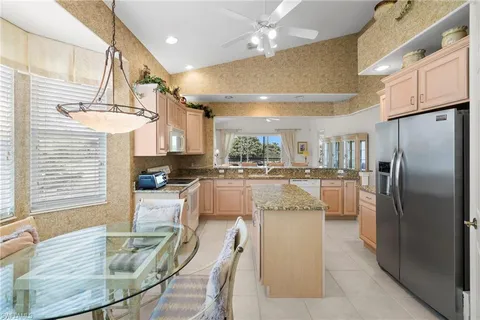 a kitchen with stainless steel appliances refrigerator dining table and chairs