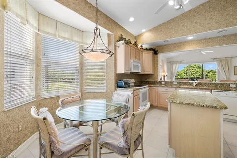 a kitchen with a table chairs sink and cabinets