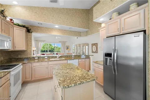 a kitchen with stainless steel appliances granite countertop a refrigerator sink and stove