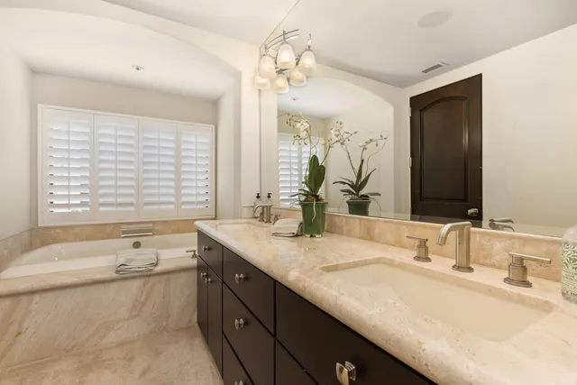 a bathroom with a granite countertop sink and a bathtub