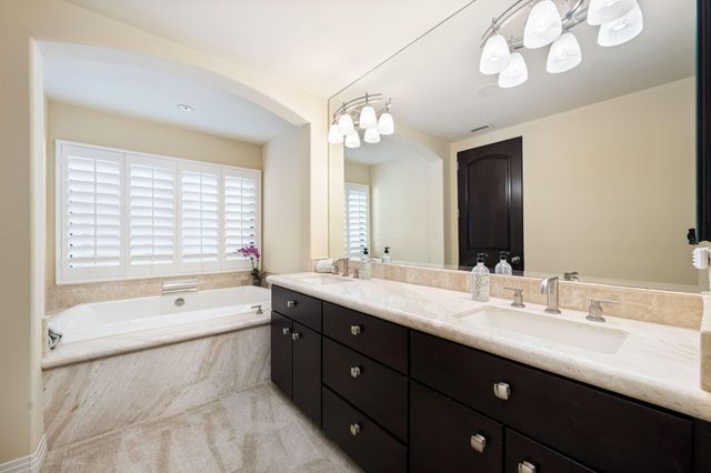 a bathroom with a large tub sink and double vanity