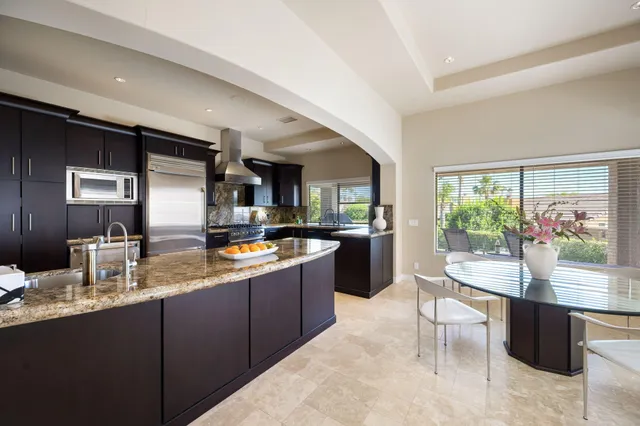 a kitchen with granite countertop lots of counter top space sink and stainless steel appliances