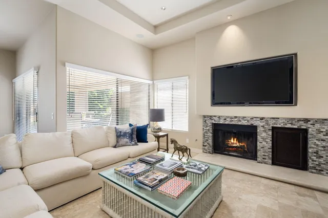 a living room with furniture a flat screen tv and a fireplace