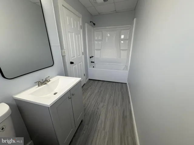 a bathroom with a sink a toilet and a mirror