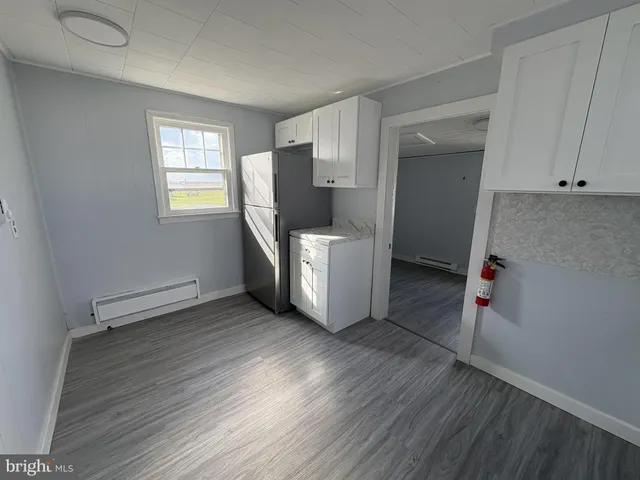 a view of a kitchen with wooden floor and electronic appliances