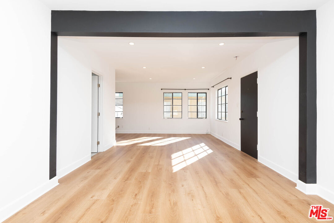a view of empty room with wooden floor