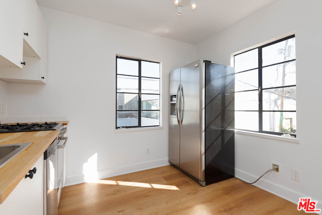 822 North Detroit Street, Unit 826 5 Los Angeles, CA 90046 - Photo 4 of 14 a view of a kitchen with a fridge and wooden floor