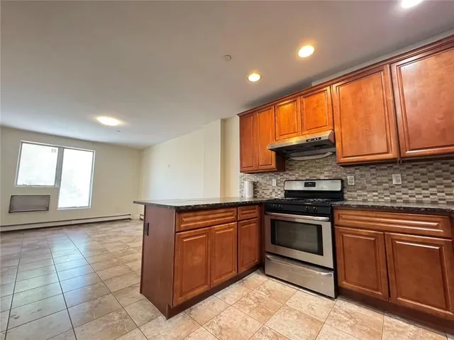 a kitchen with stainless steel appliances granite countertop a stove a sink and a microwave