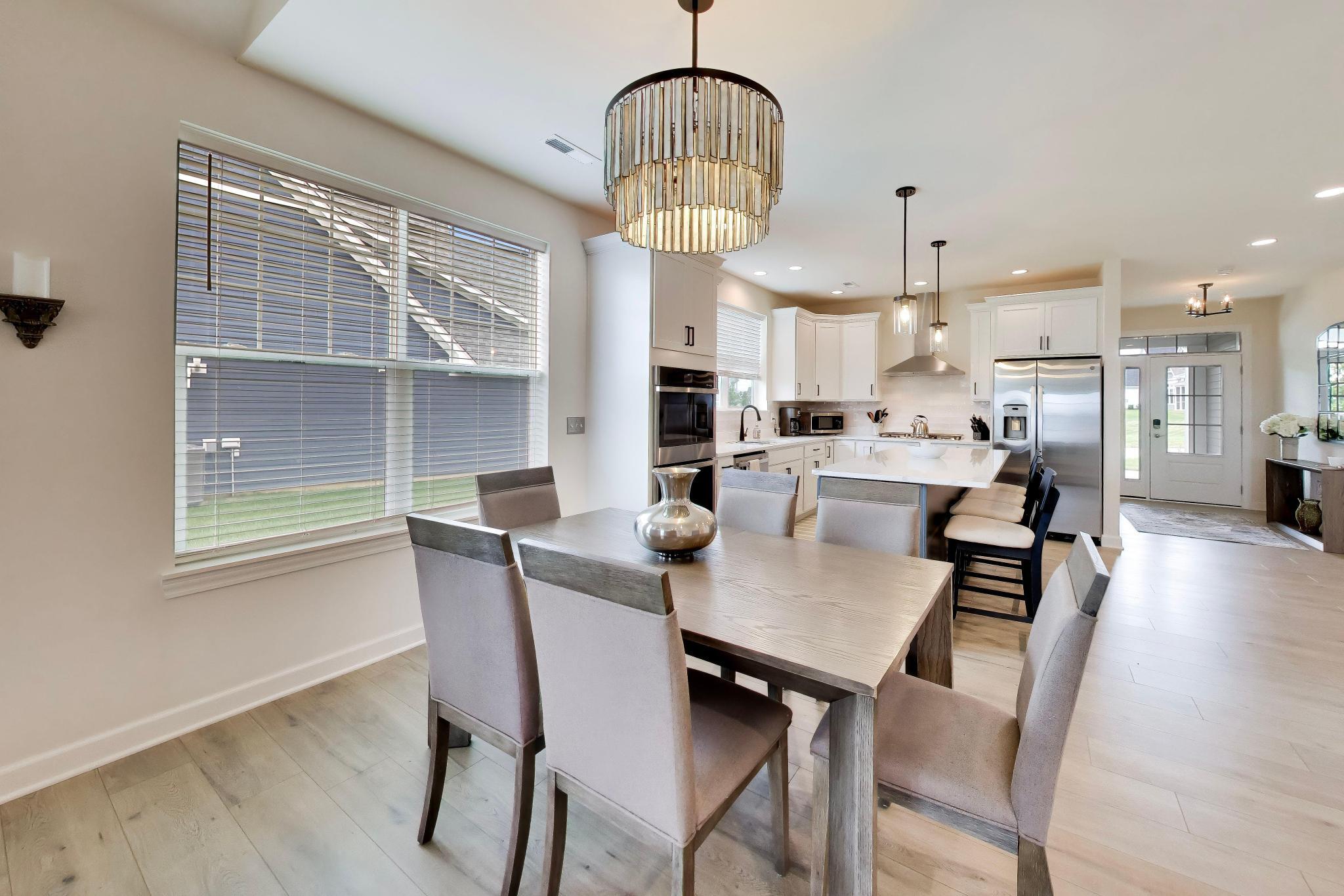 2730 Harbor Court Delavan, WI 53115 - Photo 12 of 47 Dining area and kitchen with large island, pendant lighting, stainless appliances, and open sightline to the foyer.