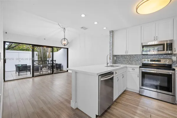 a kitchen with stainless steel appliances granite countertop a stove a sink and a microwave