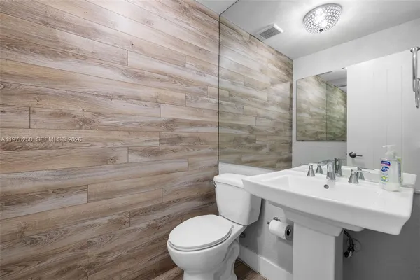 a bathroom with a sink toilet and a mirror