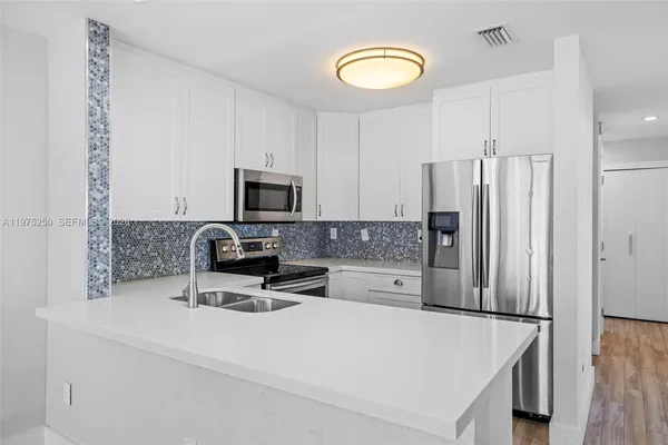 a kitchen with stainless steel appliances a refrigerator stove microwave and sink