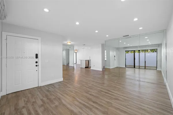 a view of an empty room with wooden floor
