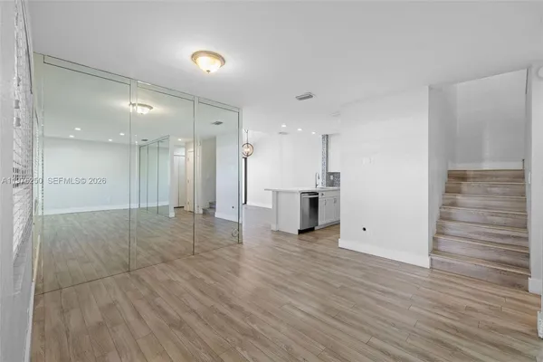 a view of an empty room with wooden floor