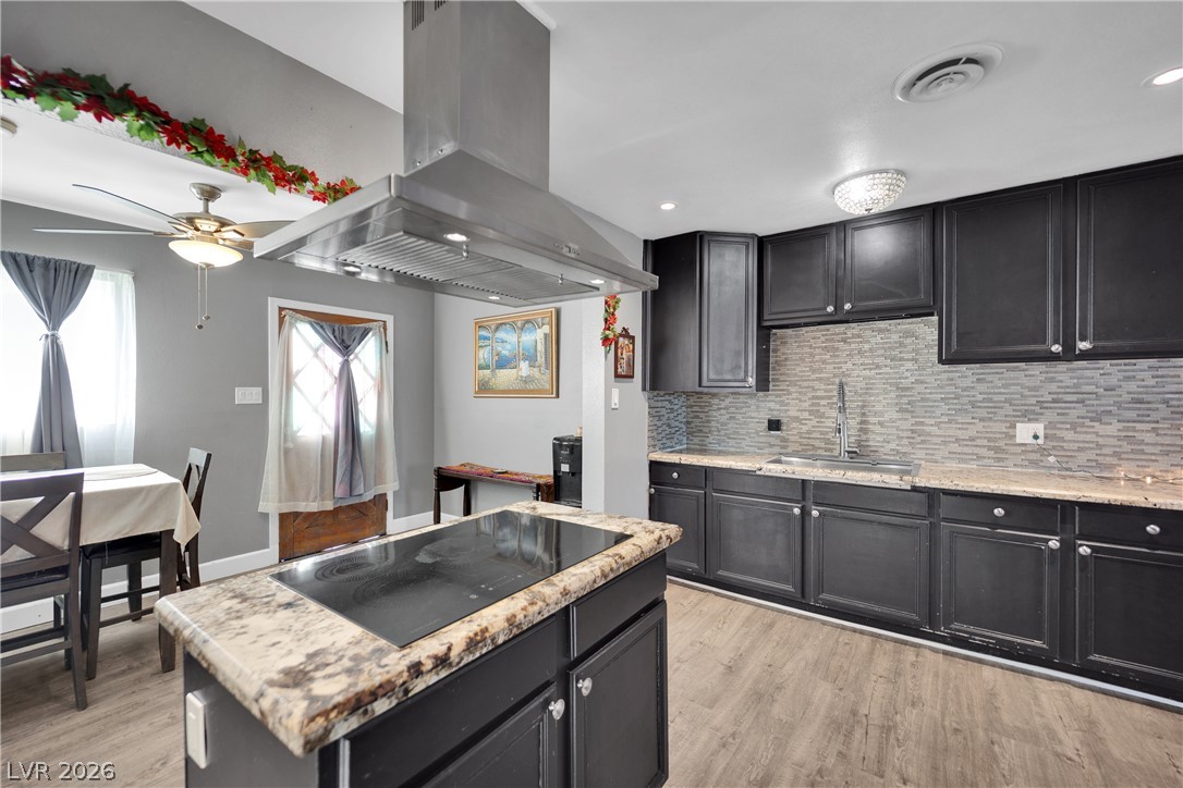 2221 Englestad Street North Las Vegas, NV 89030 - Photo 9 of 32 A well-appointed kitchen features ample cabinetry, a central island cooktop, and a sleek range hood.