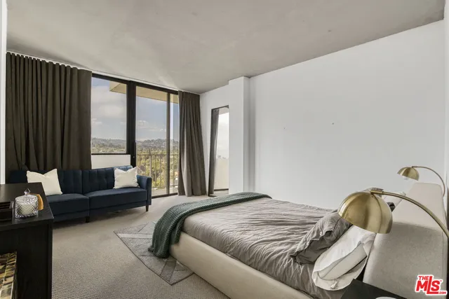 a bedroom with furniture and a large window