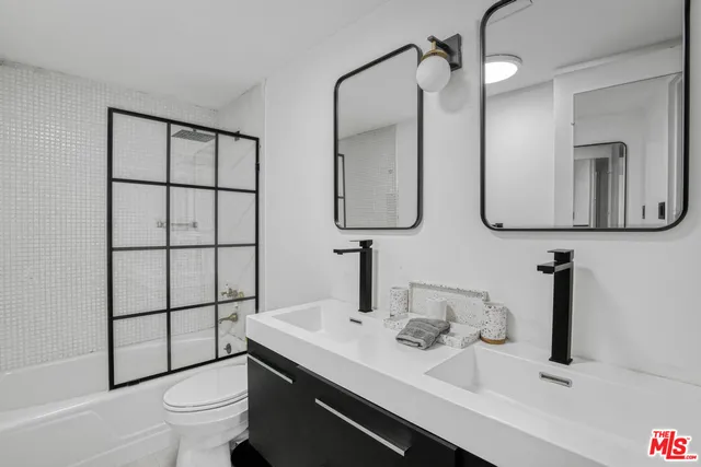 a bathroom with a sink a toilet and mirror