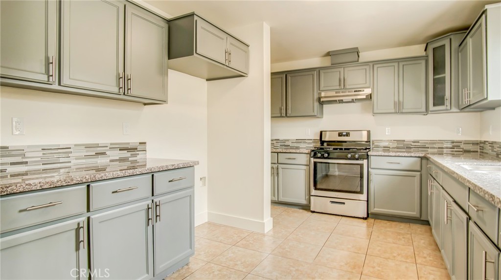 a kitchen with stainless steel appliances granite countertop a sink and a stove