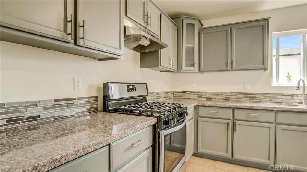 330 East 101st Street Los Angeles, CA 90003 - Photo 4 of 15 a kitchen with stainless steel appliances granite countertop a sink stove and cabinets