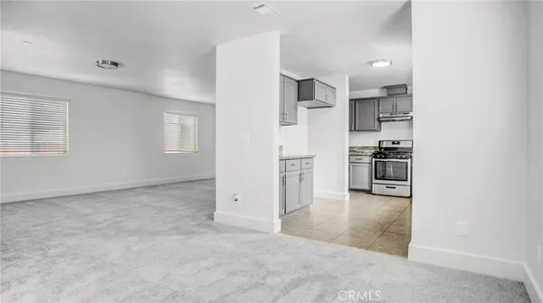 an empty room with kitchen appliances and windows