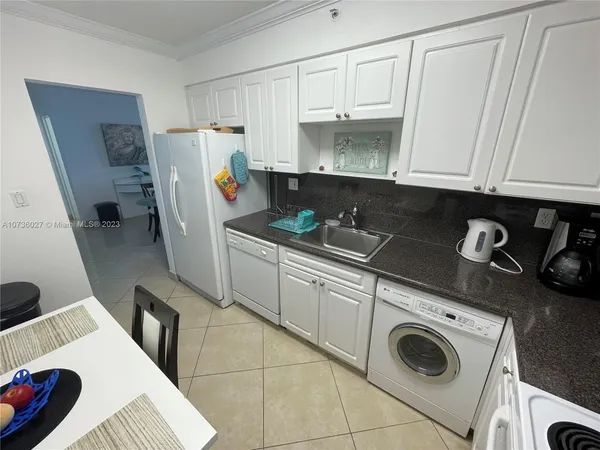 a living room with lots of furniture and kitchen view