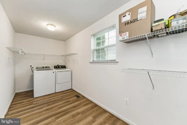 a view of a kitchen with white cabinets and wooden floor
