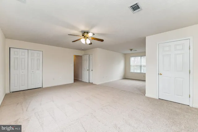 an empty room with windows and closet
