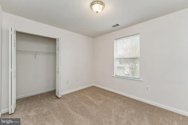 an empty room with windows and closet