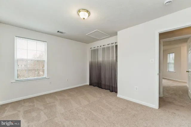 an empty room with windows and closet