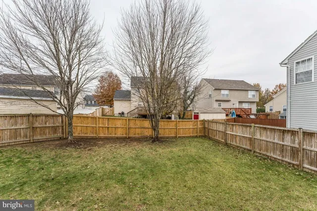 a view of a house with a large tree and a yard