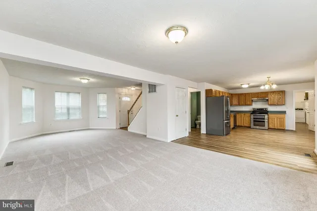 a view of an empty room with a window and fireplace