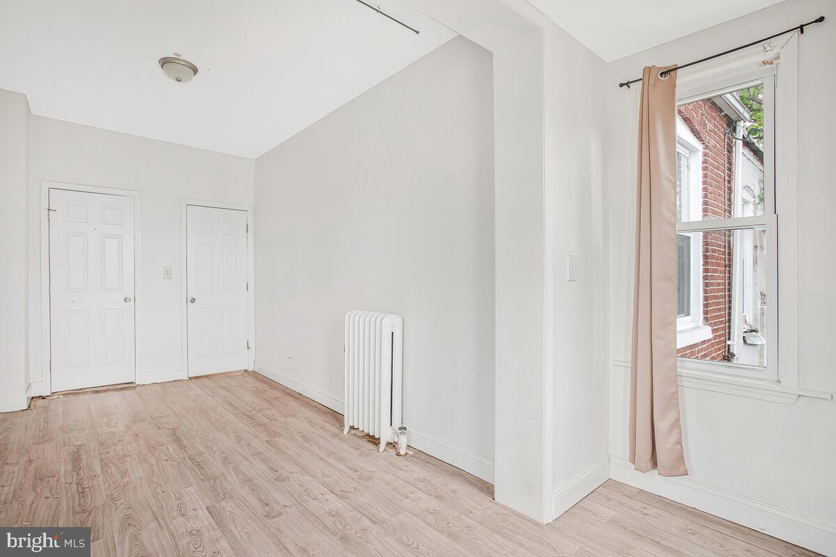 3516 Reisterstown Road Baltimore, MD 21215 - Photo 12 of 21 a view of an empty room with wooden floor and a window