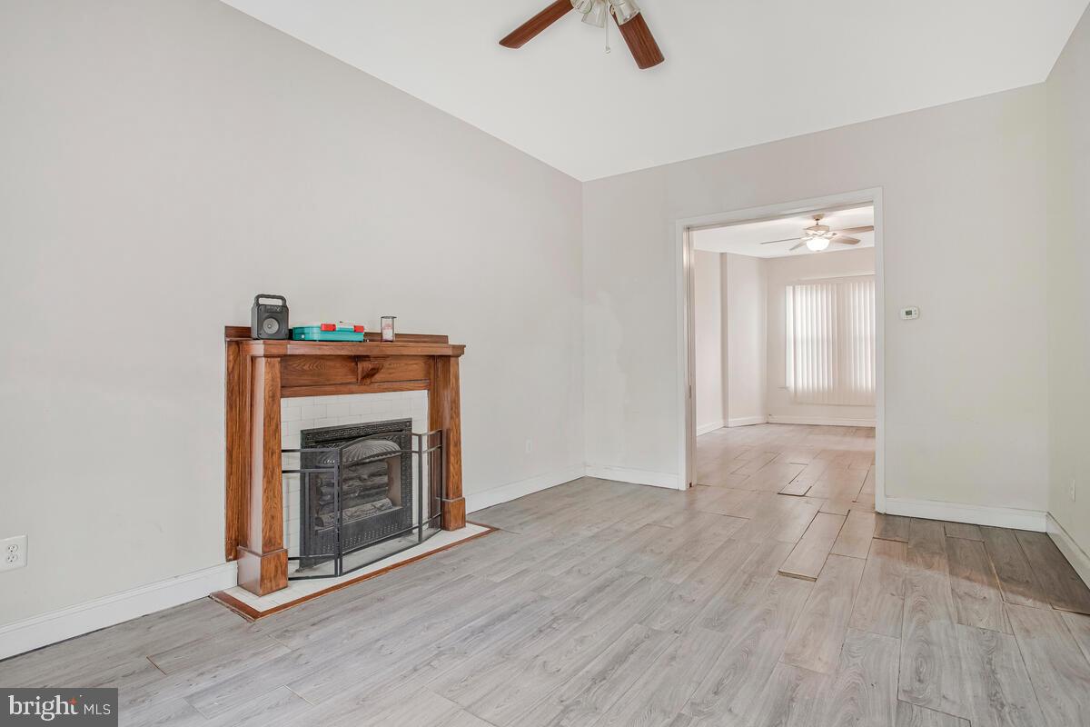 3516 Reisterstown Road Baltimore, MD 21215 - Photo 8 of 21 a view of an empty room with wooden floor and a fireplace