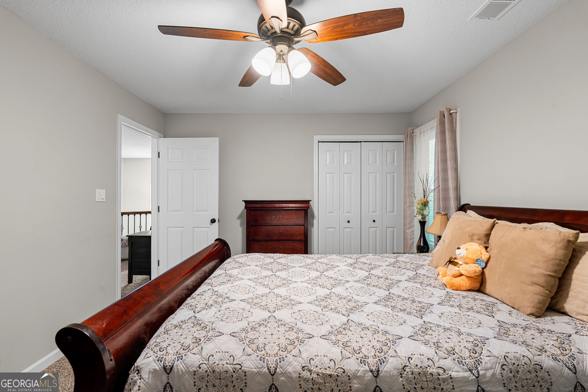 375 Gaelic Way Tyrone, GA 30290 - Photo 26 of 54 a bedroom with a large bed and a chandelier