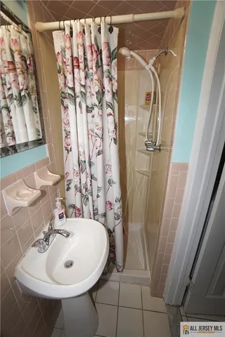 a bathroom with a sink and mirror with bathtub