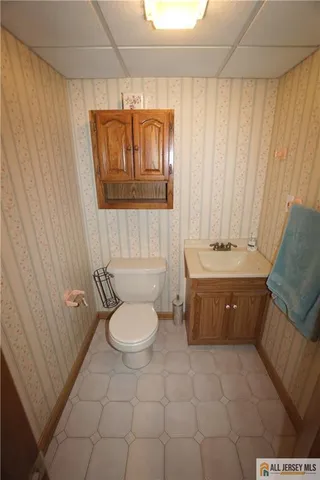 a bathroom with a granite countertop bathtub sink vanity mirror and toilet