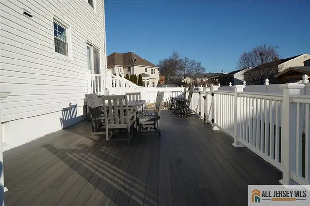 a view of a patio with table and chairs with wooden floor and fence
