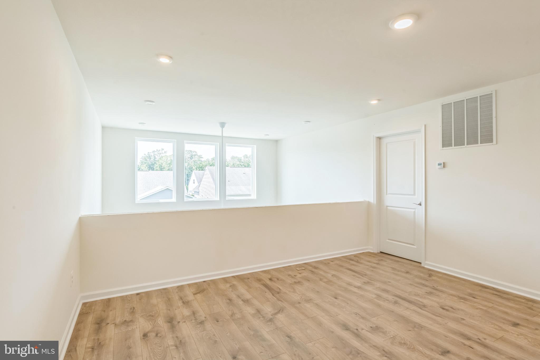 390 Scranton Lane Ocean View, DE 19970 - Photo 12 of 15 an empty room with wooden floor and windows