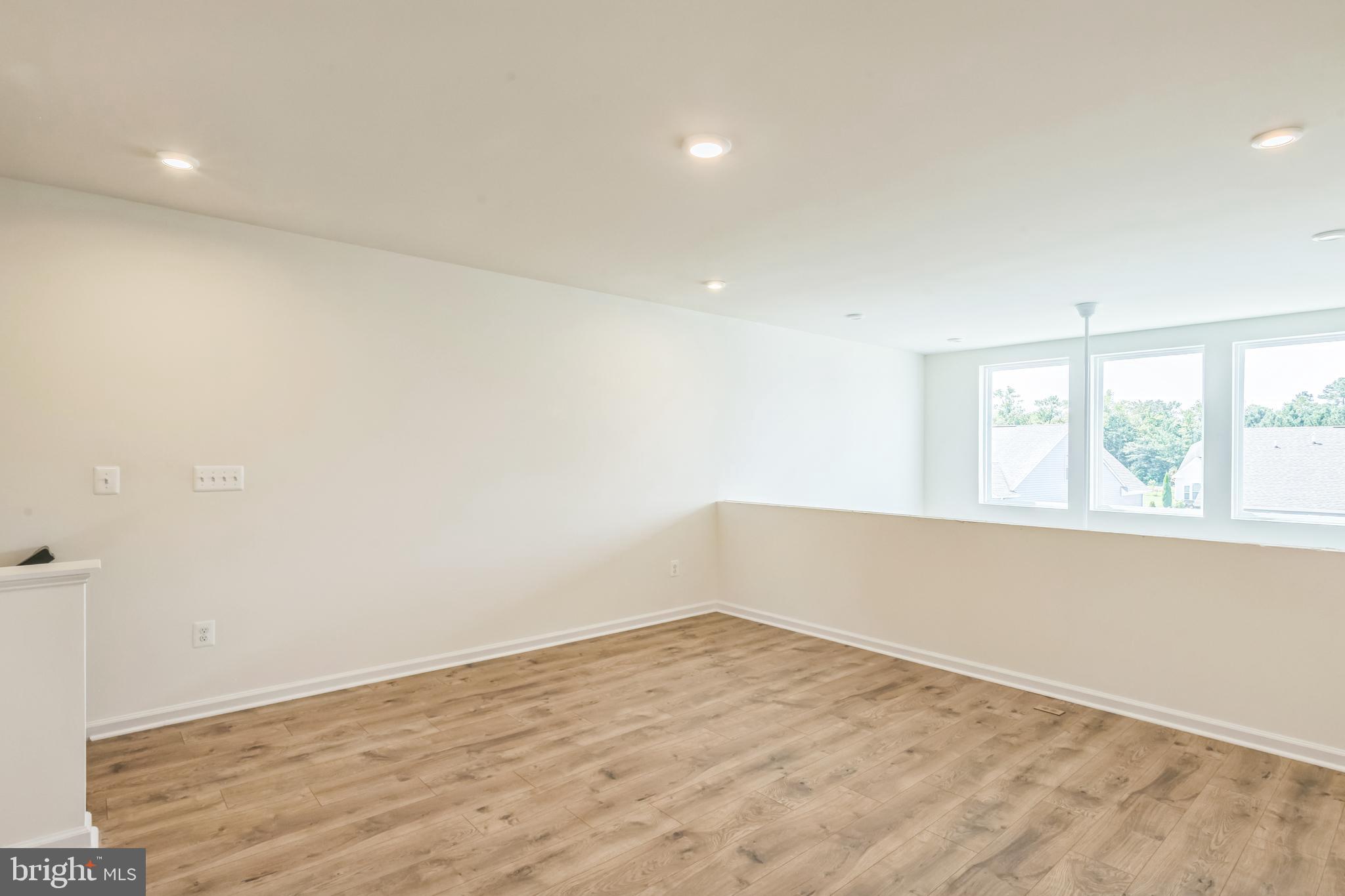 390 Scranton Lane Ocean View, DE 19970 - Photo 13 of 15 an empty room with wooden floor and windows