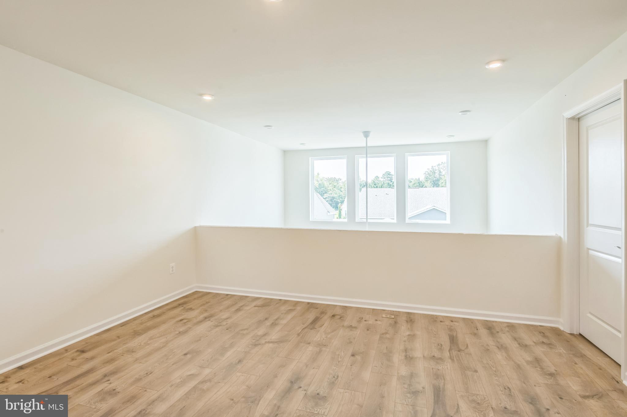 390 Scranton Lane Ocean View, DE 19970 - Photo 14 of 15 an empty room with wooden floor and windows