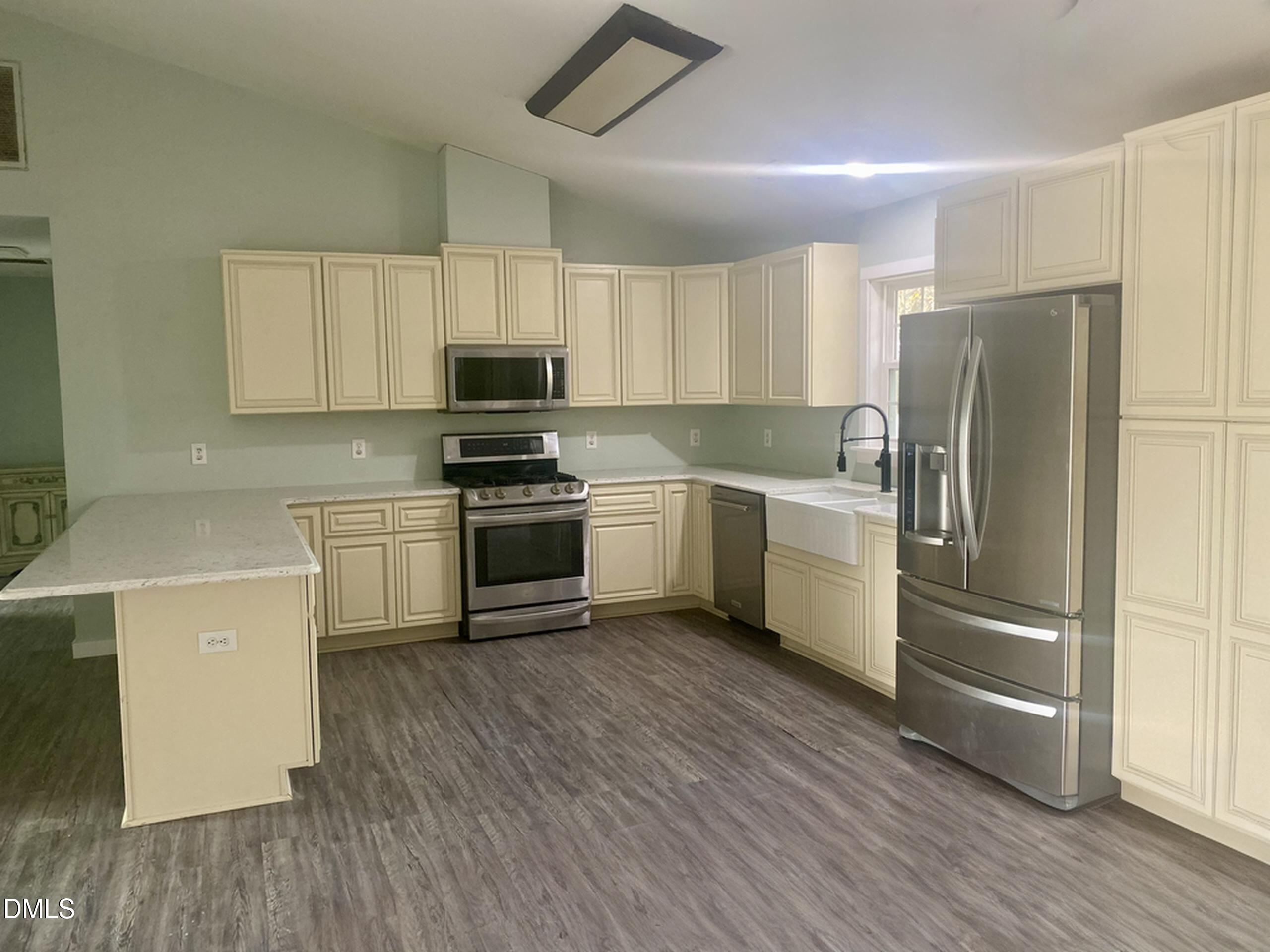 3182 Sims Bridge Road Kittrell, NC 27544 - Photo 7 of 44 a kitchen with a sink a refrigerator and cabinets