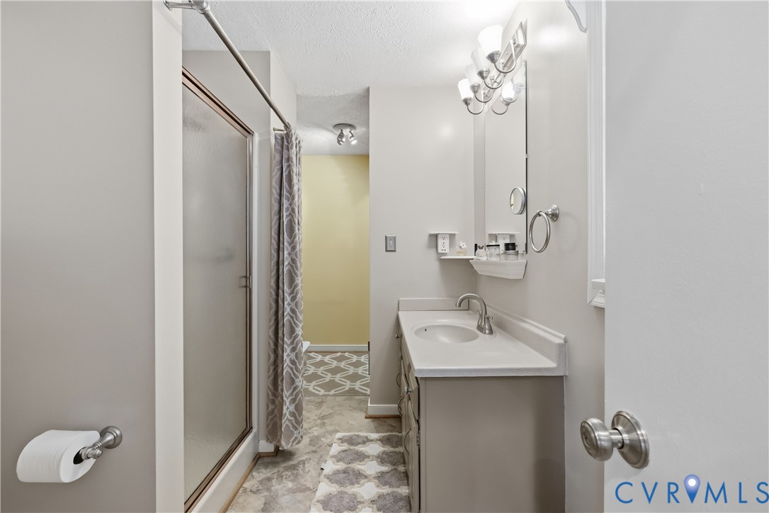 5800 West Rois Road Richmond, VA 23227 - Photo 16 of 32 a bathroom with a sink a mirror and shower