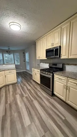 a kitchen with a stove sink and cabinets