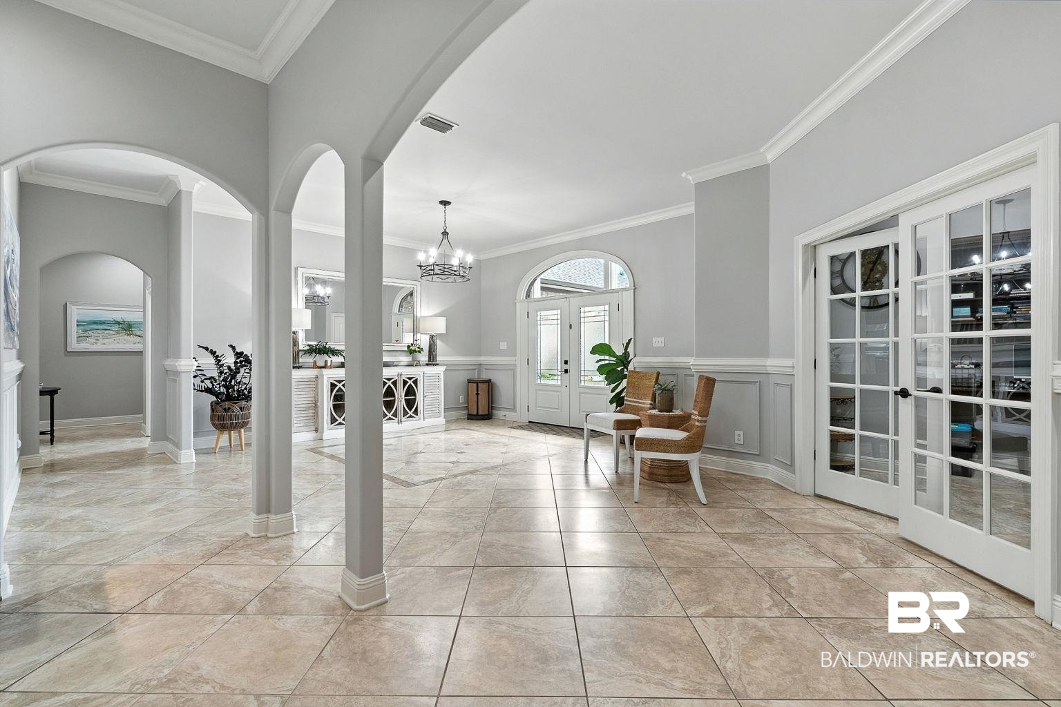 23357 Carnoustie Drive Foley, AL 36535 - Photo 7 of 99 Foyer with arched walkways, ornamental molding, a chandelier, french doors, and light tile patterned floors