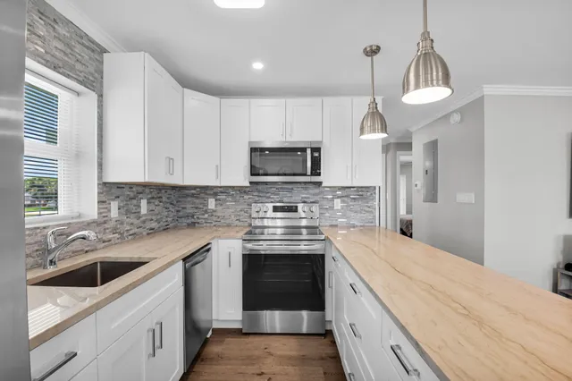 a kitchen with stainless steel appliances granite countertop a stove and a sink
