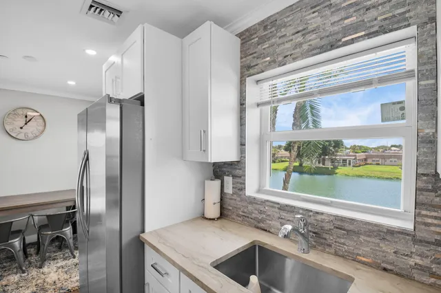 a kitchen with stainless steel appliances granite countertop a refrigerator and a sink