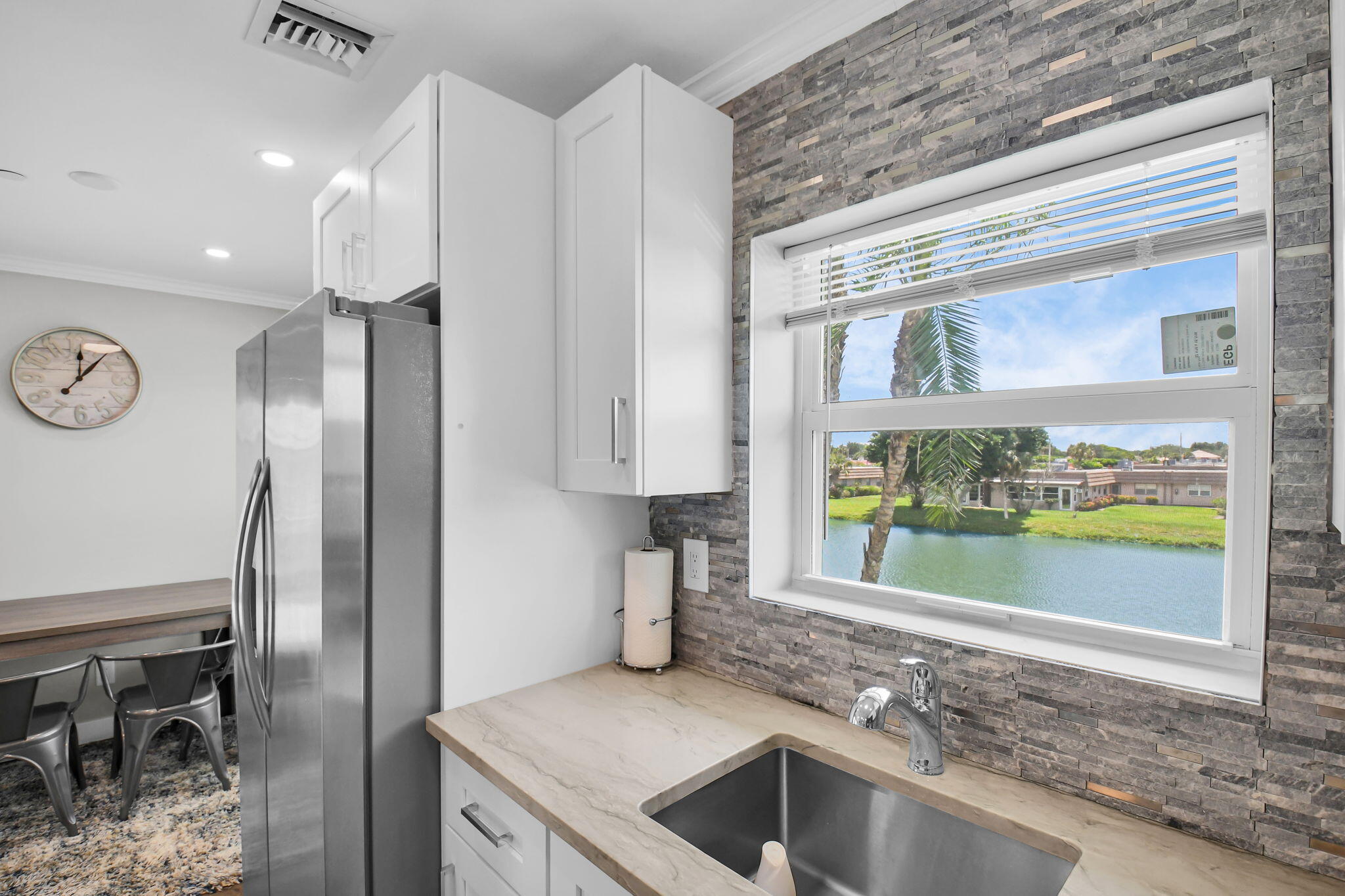 388 Tuscany Lane, Unit 388 Delray Beach, FL 33446 - Photo 14 of 40 a kitchen with stainless steel appliances granite countertop a refrigerator and a sink