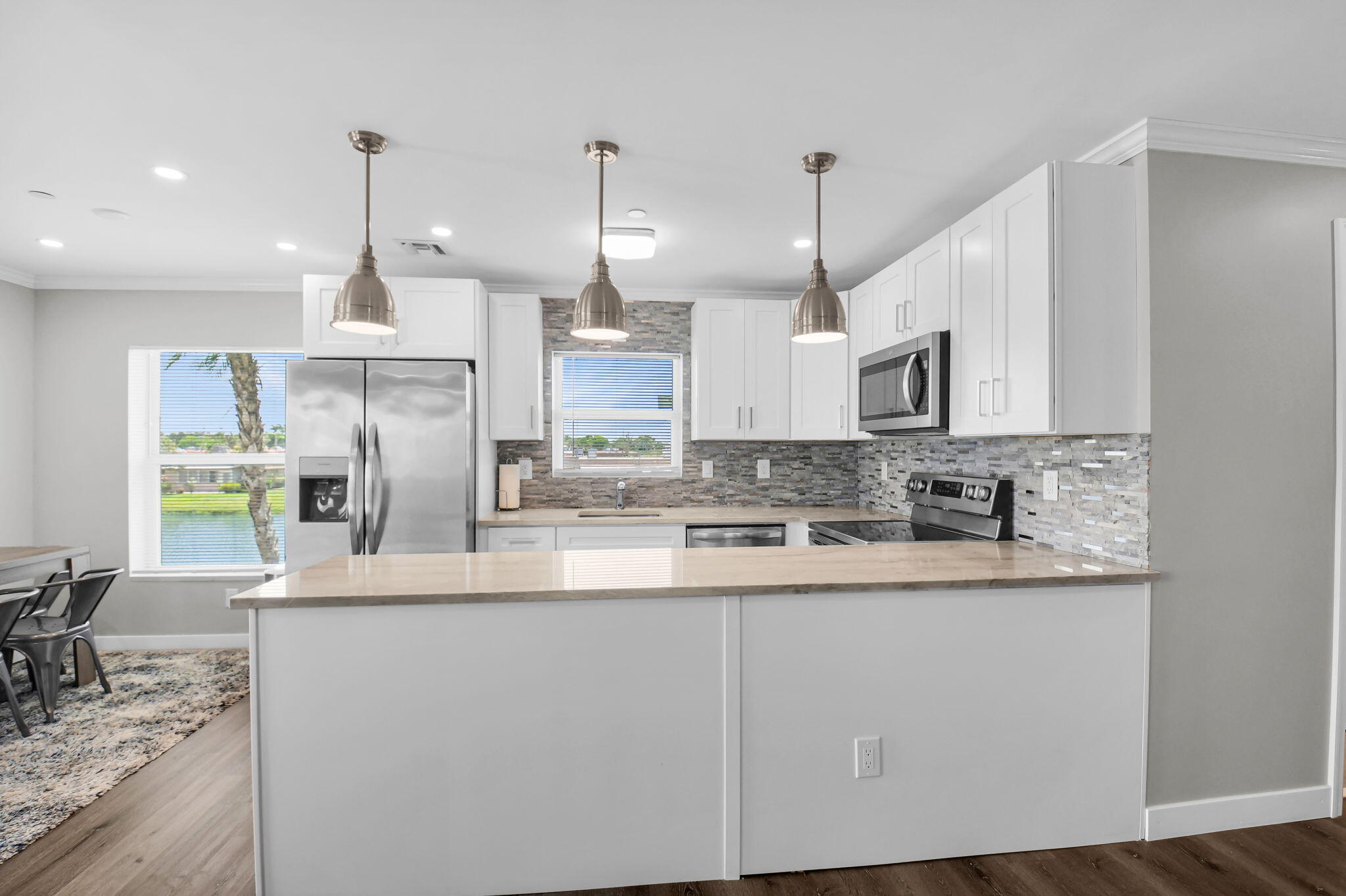 388 Tuscany Lane, Unit 388 Delray Beach, FL 33446 - Photo 15 of 40 a kitchen with stainless steel appliances granite countertop a sink a stove a refrigerator a center island and cabinets